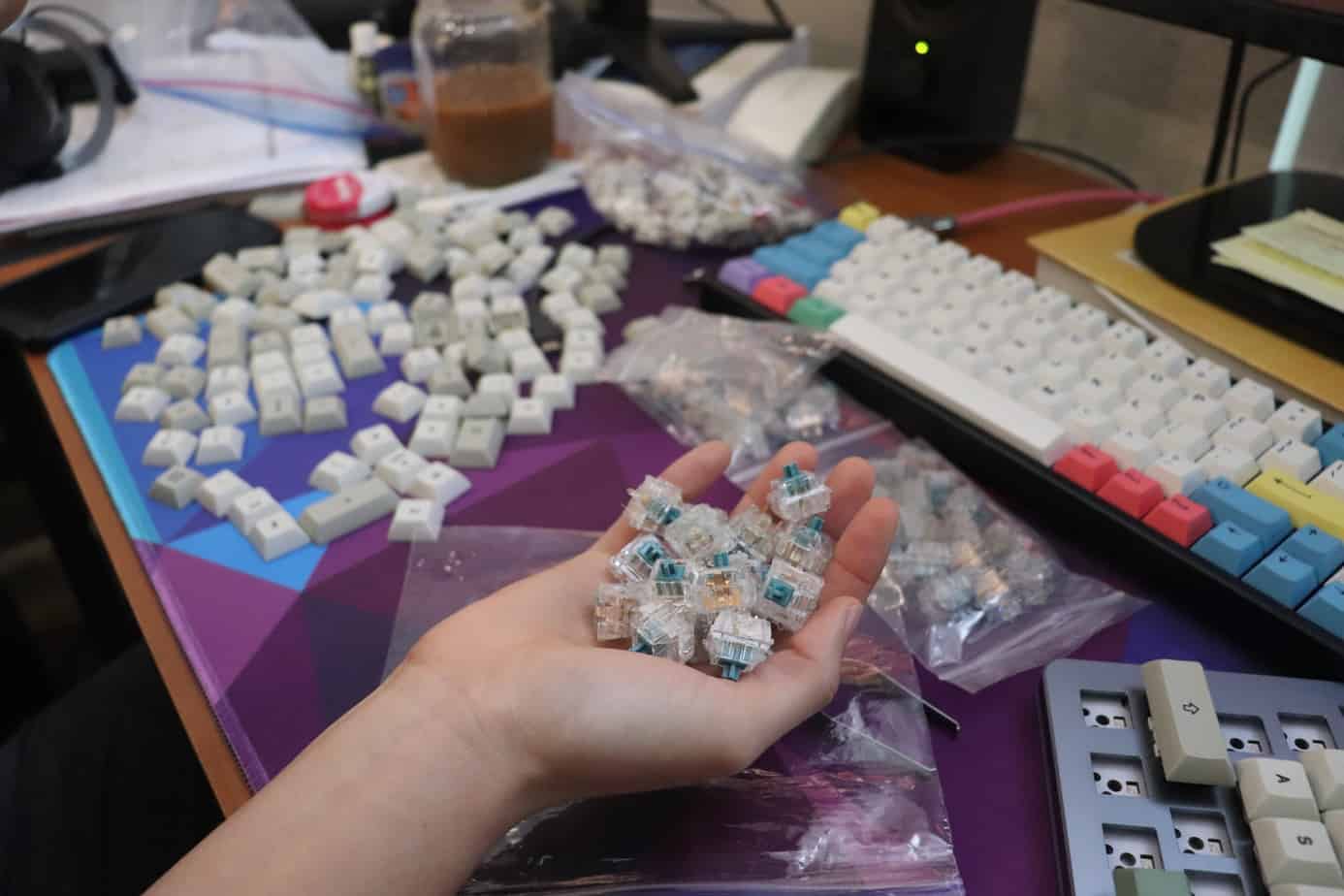 someone holding switches round disassembled keyboard