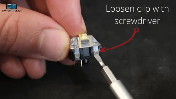 loosening first clip on mechanical keyboard switch with screwdriver