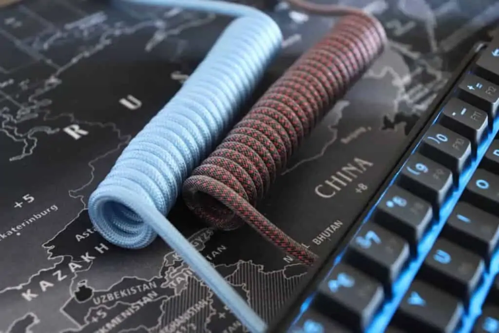 Custom coiled USB-C mechanical keyboard cables side-by-side in red and blue.