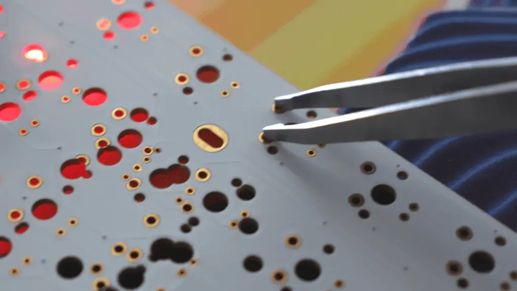 tweezers being used to test mechanical keyboard PCB