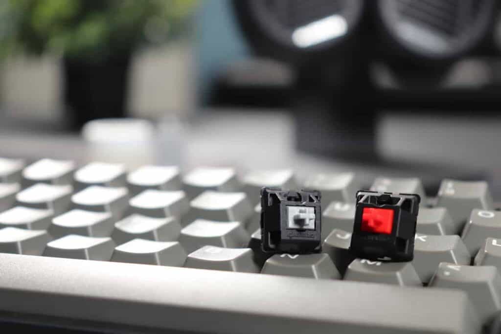 Close up of Cherry MX Speed Silver switch next to Cherry MX Red switch on keyboard.