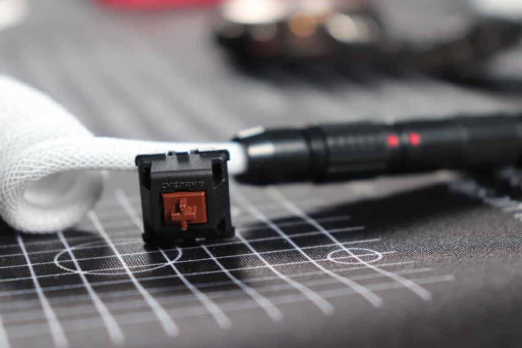 Cherry MX Brown switch sitting next to coiled cable on desk mat