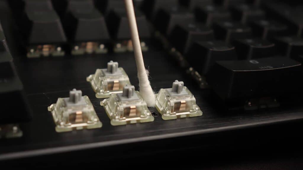 Top plate of mechanical keyboard being cleaned with a cotton swab